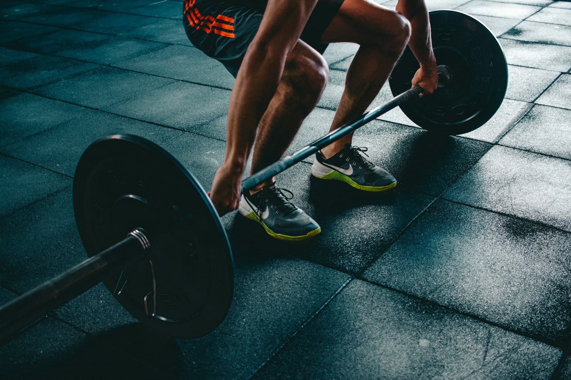 An athlete setting up for a barbell deadlift in the gym